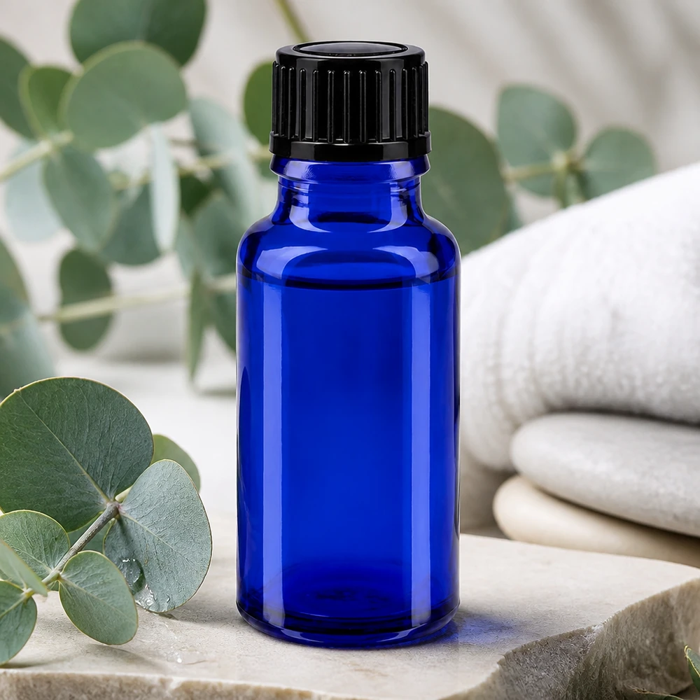 Liten blå apoteksflaska på 20 ml med svart lock på natursten med eukalyptus