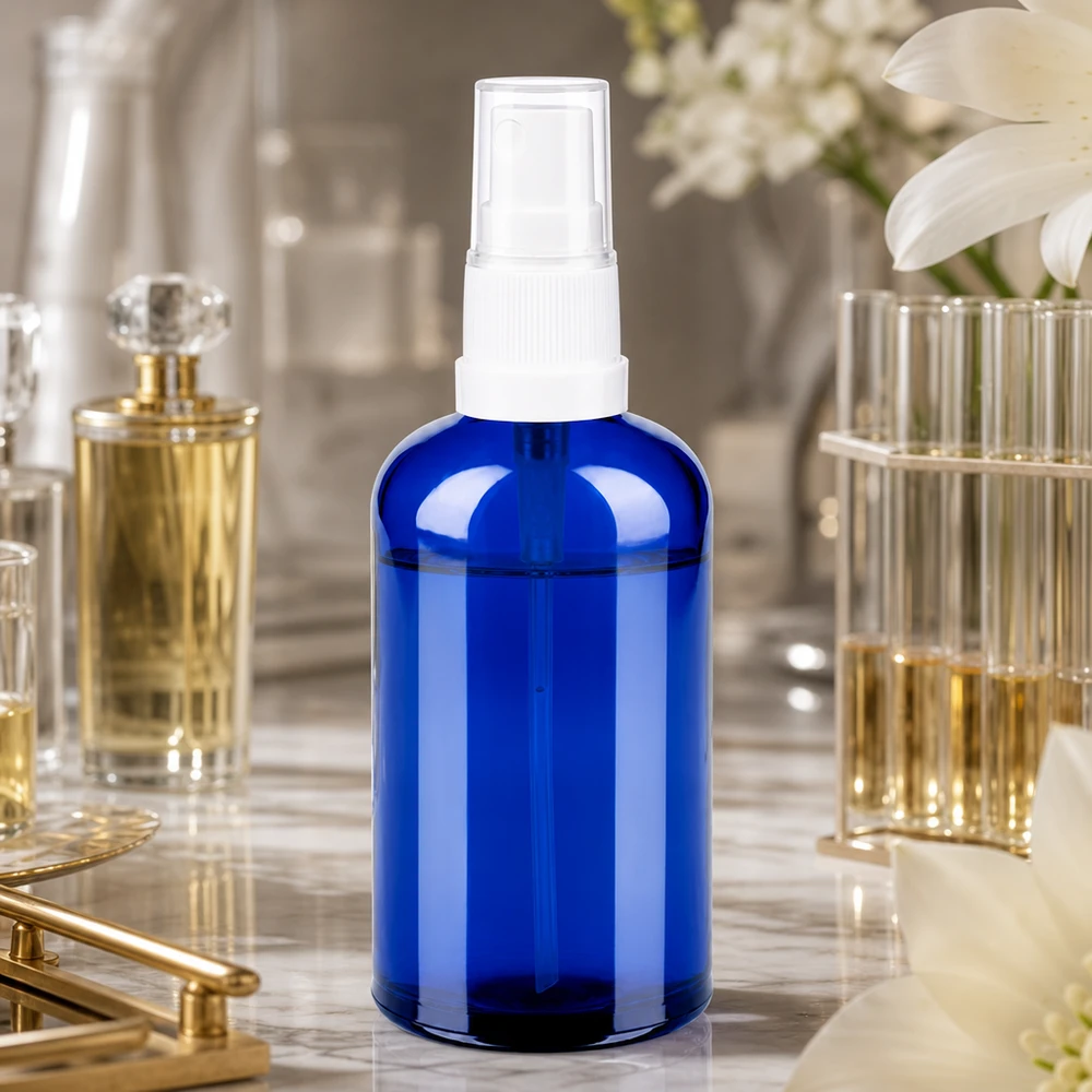 Transparent 100 ml blå sprayflaska med vit atomiserare, idealisk för parfym och rumssprayer