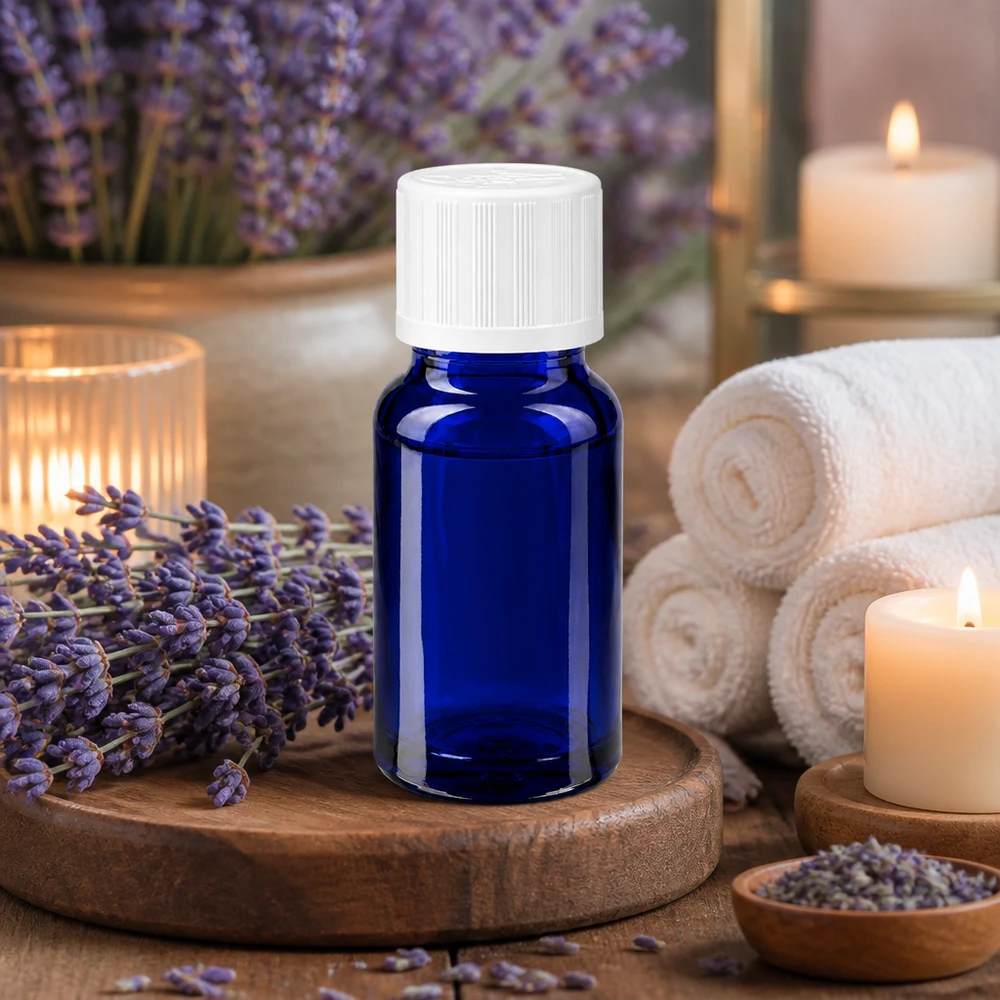 Apoteksflaska blå 10ml skruvkork vit barnsäker standard Blå glasflaska på 10 ml med vitt barnsäkert lock, omgiven av lavendelblommor och ljus