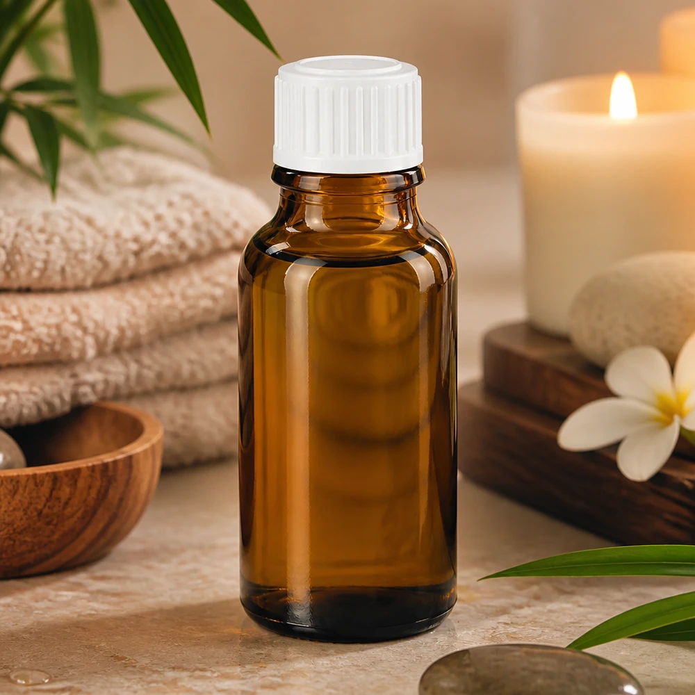 Apoteksflaska brun 20ml skruvlock vit standard Brun 20 ml apoteksflaska i glas med vitt lock på marmor bredvid ett ljus och en plumeria