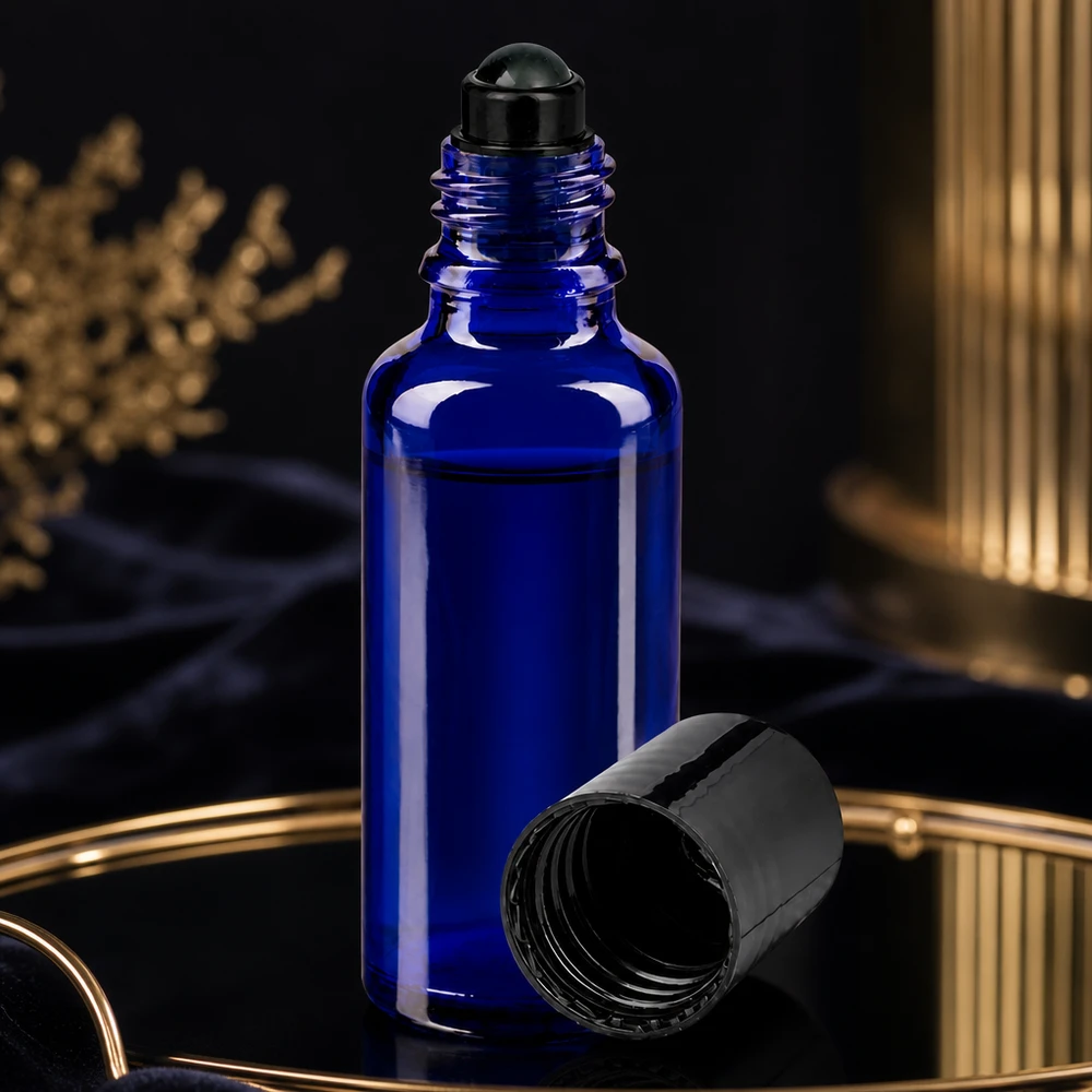 Blå roll-on-flaska på 30 ml med öppet svart skruvlock på ett guldfärgat fat