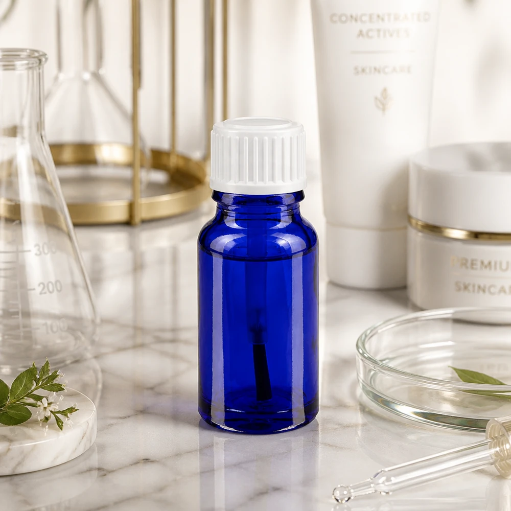 Apoteksflaska blå 10ml skruvlock vit borste Liten blå glasflaska på 10 ml med vitt skruvlock på marmor bland laboratorieutrustning