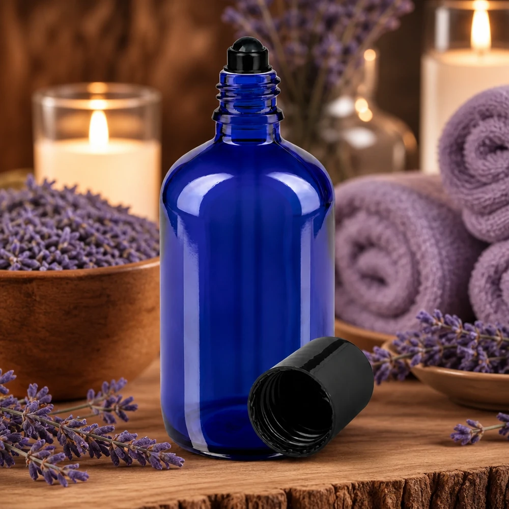 Apoteksflaska blå 100ml roll-on lock svart Blå glasflaska på 100 ml med roll-on-lock, omgiven av lavendelblommor och ljus