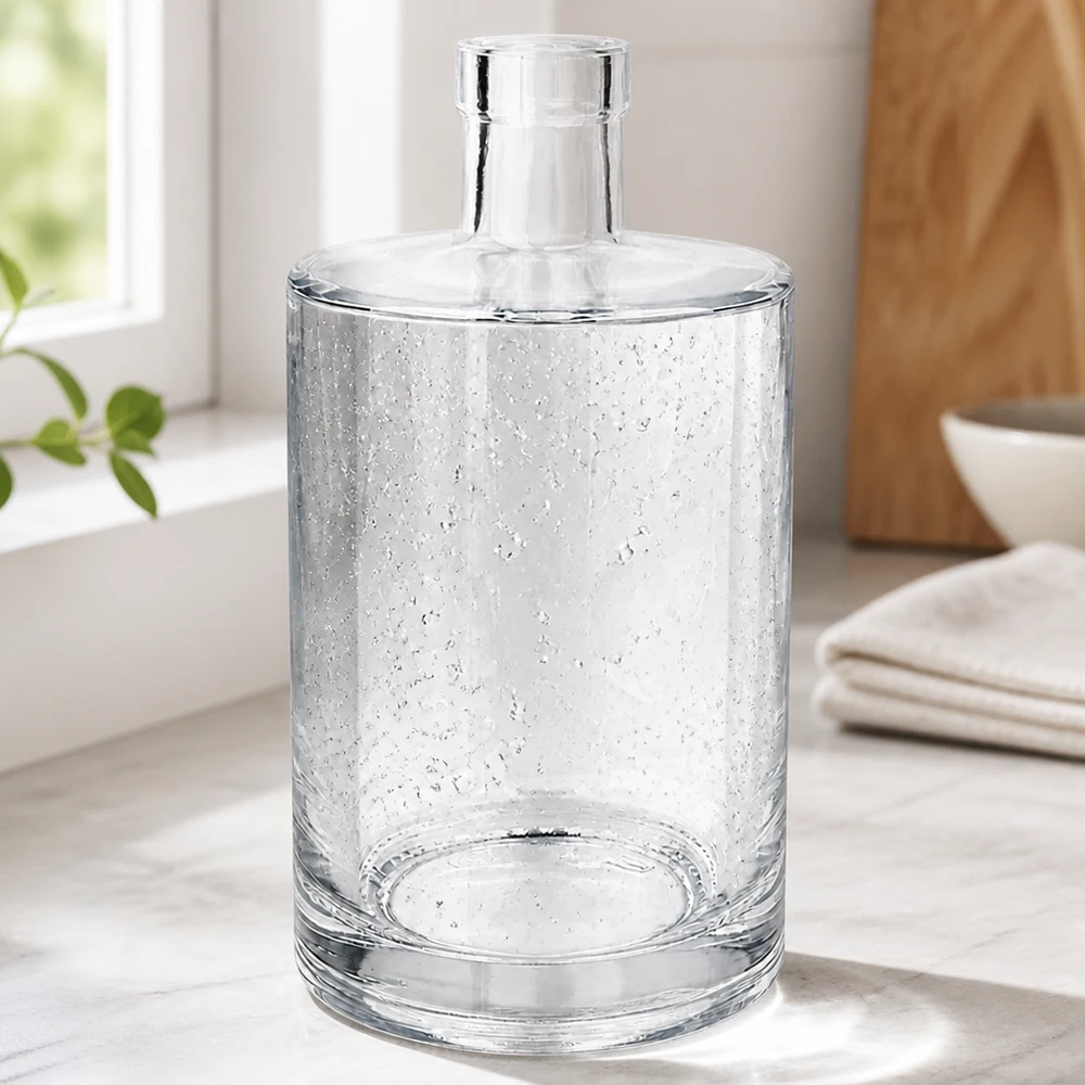 700 ml glasflaska Marie utan förslutning UNiTWIST® Elegante 700ml Glasflasche Marie mit Luftbläschen-Optik in modernem Wohnambiente neben Handtüchern und Holzschale