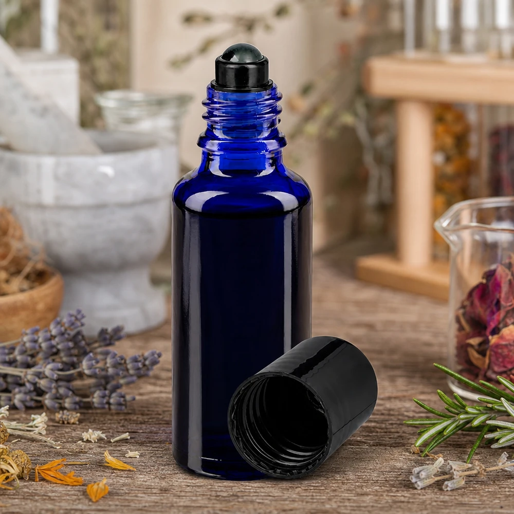 Koboltblå 30 ml ApoGlas-flaska med svart roll-on-munstycke bland torkade örter