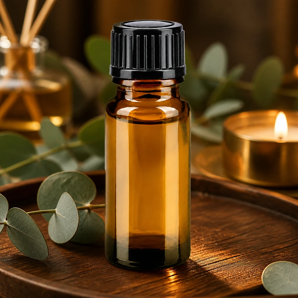 Liten 10 ml-flaska i brunt glas med svart lock på en träbricka med eukalyptus