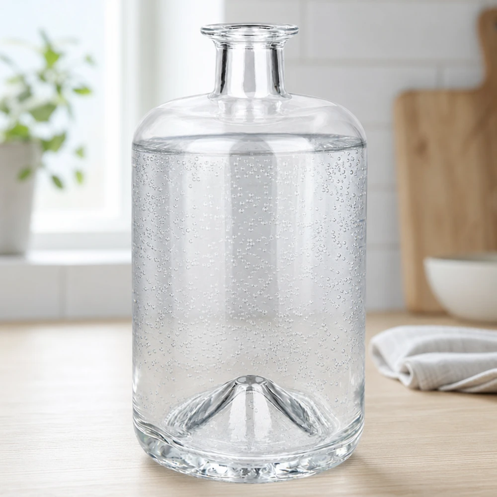 700 ml apoteksflaska Sofia utan lock UNiTWIST® 700 ml Sofia glasflaska fylld med kolsyrat vatten visar koldioxidbubblor i en ljus köksmiljö