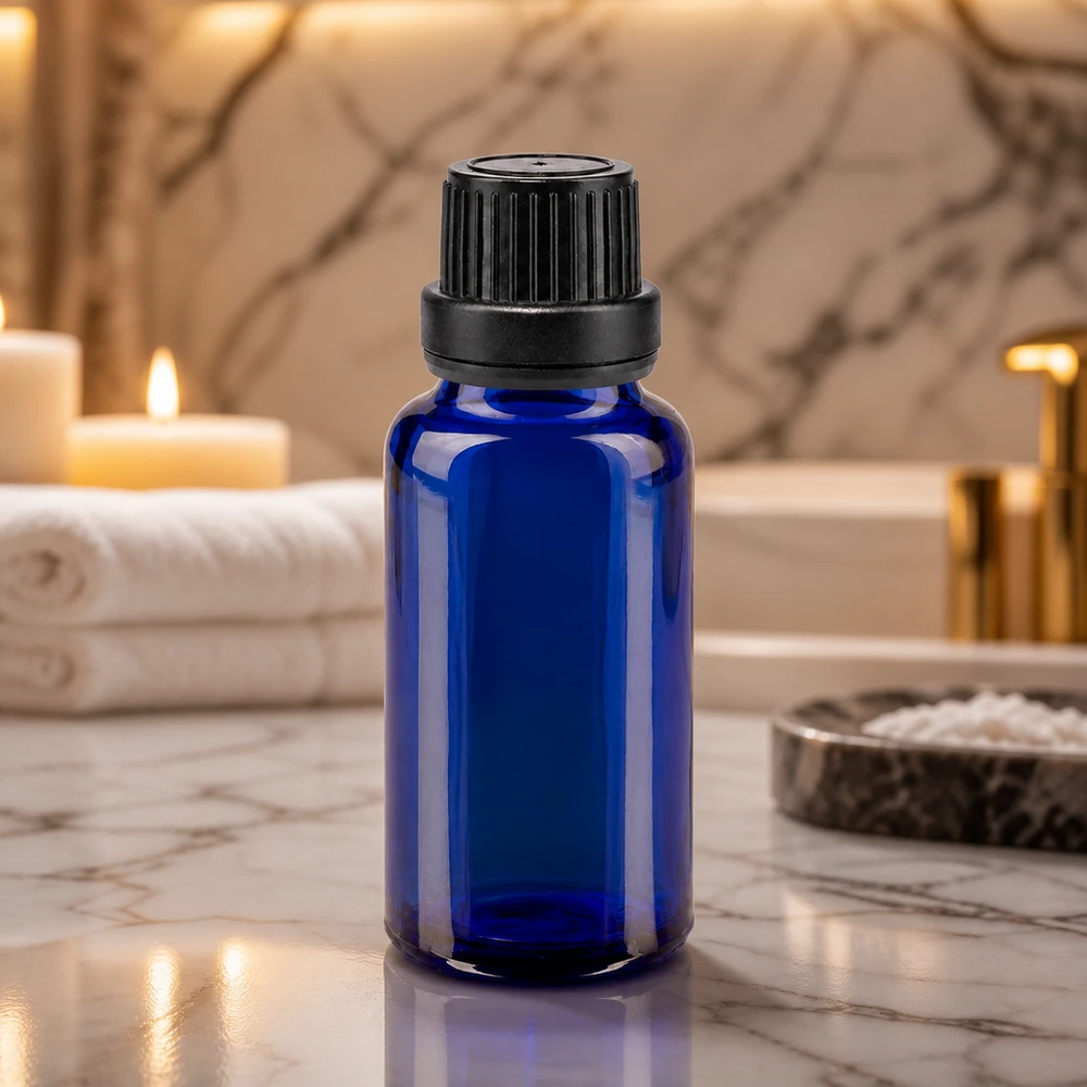 Koboltblått apotekerglas på 20 ml med svart OV-lock på marmor i wellness-badrummet