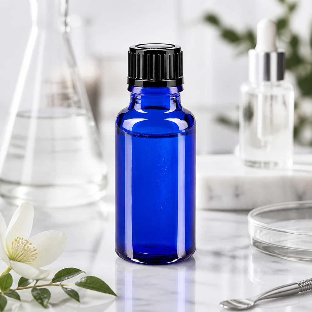 Apoteksflaska blå 20ml droppflaska 1mm svart standard Koboltblå glasflaska på 20 ml med svart barnsäkerhetslock på marmorunderlägg