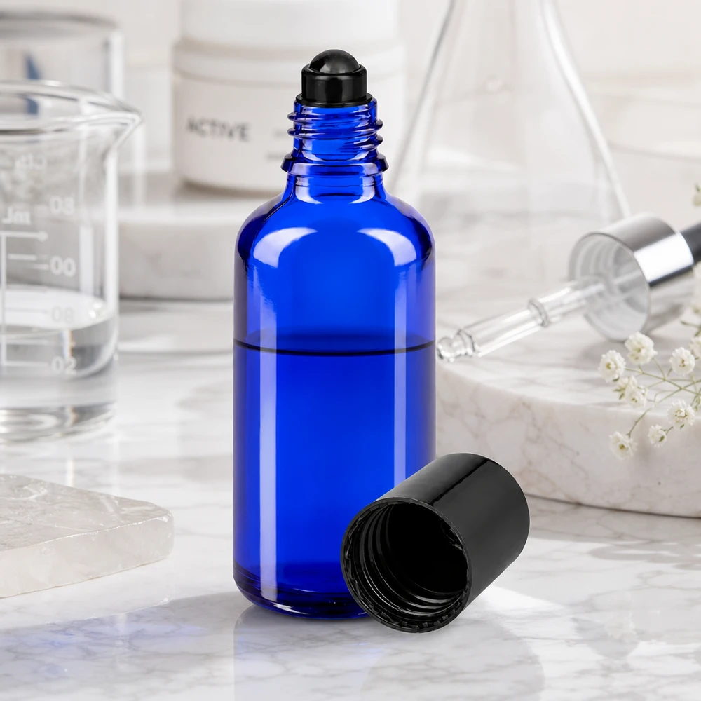 Apoteksflaska blå 50ml roll-on lock svart 50 ml roll-on-flaska i koboltblått med svart skruvlock bredvid ett bägarglas och en pipett