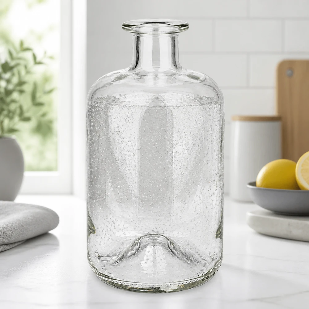 500 ml apoteksflaska 500ml Glasflasche "Luna" ohne Verschluss UNiTWIST500ml Glasflasche "Luna" ohne Verschluss UNiTWIST utan lock UNiTWIST® Apoteksflaska Luna 500ml med bubbelstruktur på en vit köksbänk bredvid citroner och växter
