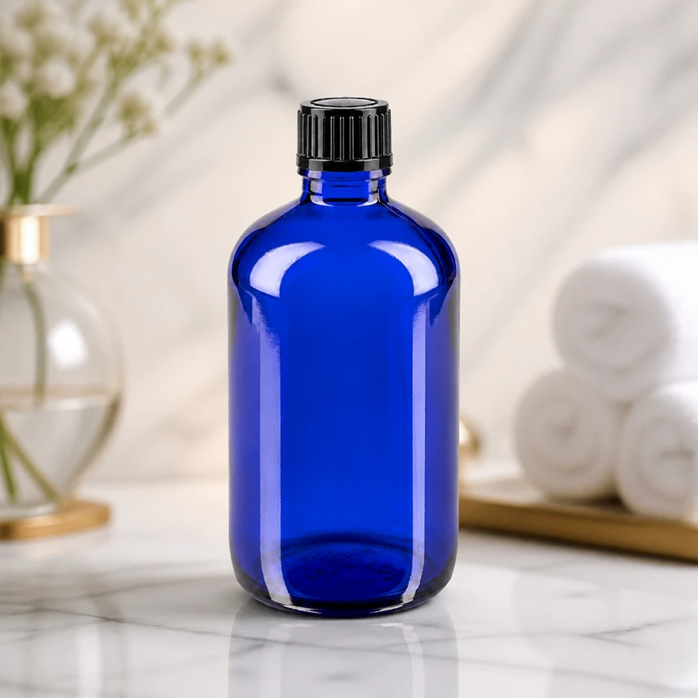Apoteksflaska blå 100ml skruvkork svart standard Cylindrisk blå glasflaska på 100 ml med räfflad svart skruvkork på marmoryta