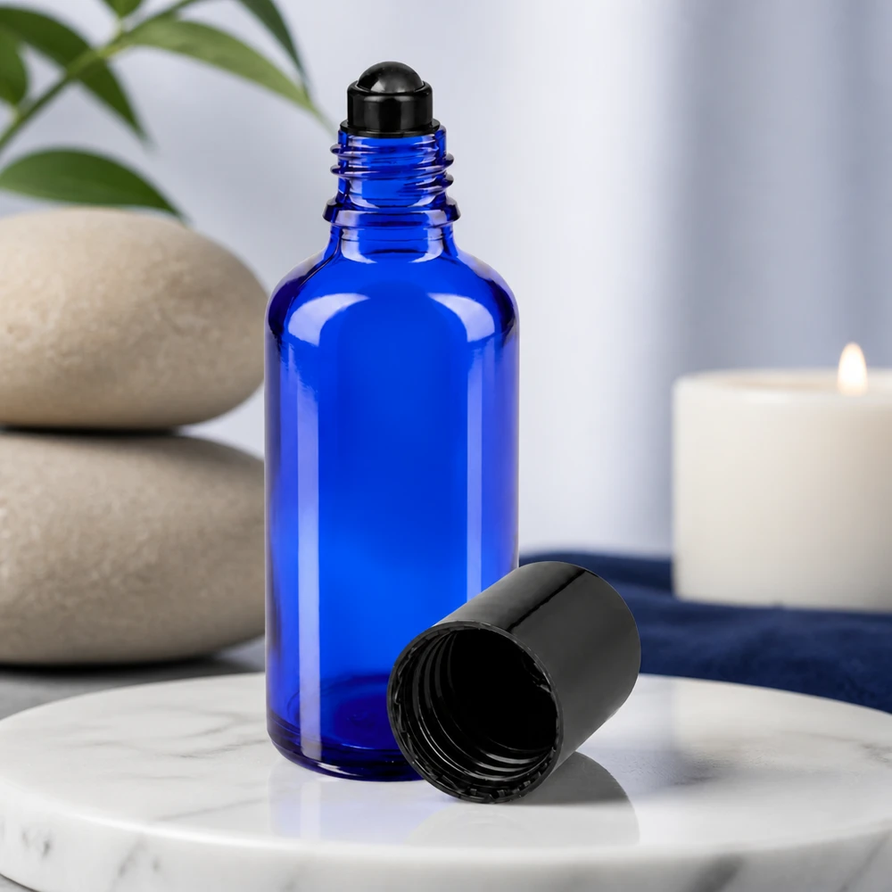 Apoteksflaska blå 50ml roll-on lock svart Blå glasflaska på 50 ml med svart roll-on-applikator och avskruvad kork på marmorunderlag