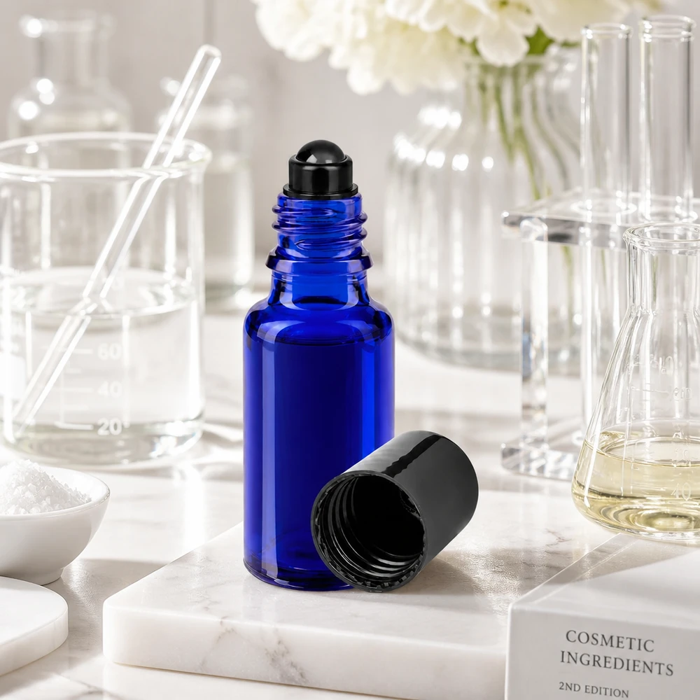 Apoteksflaska blå 20ml roll-on lock svart En öppnad 20 ml roll-on-flaska i blått med svart lock på en marmorunderlägg