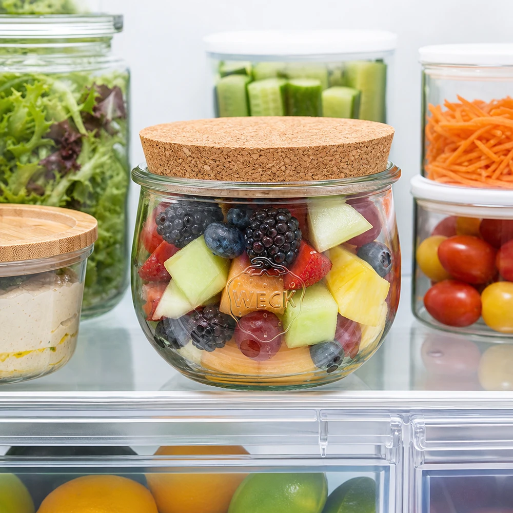 580ml tulpanburk WECK RR100 med kork naturell WECK tulpanburk 580ml med korklock i kylskåpet fylld med fruktsallad tillsammans med andra förvaringsburkar med grönsaker