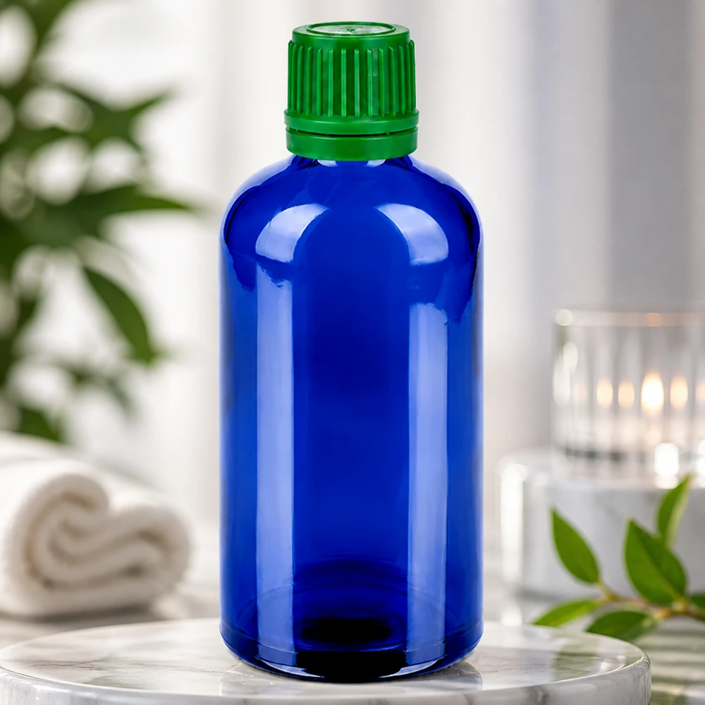 Kompakt 100 ml glasflaska i blått med grönt lock för exakt dosering och säker förvaring