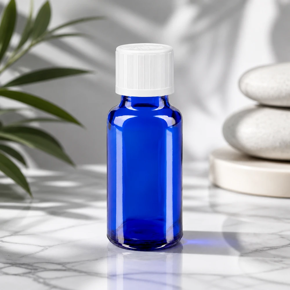 Apoteksflaska blå 20ml skruvkork vit barnsäker standard Koboltblå 20 ml apotekarflaska med vitt säkerhetslock framför Zen-stenar