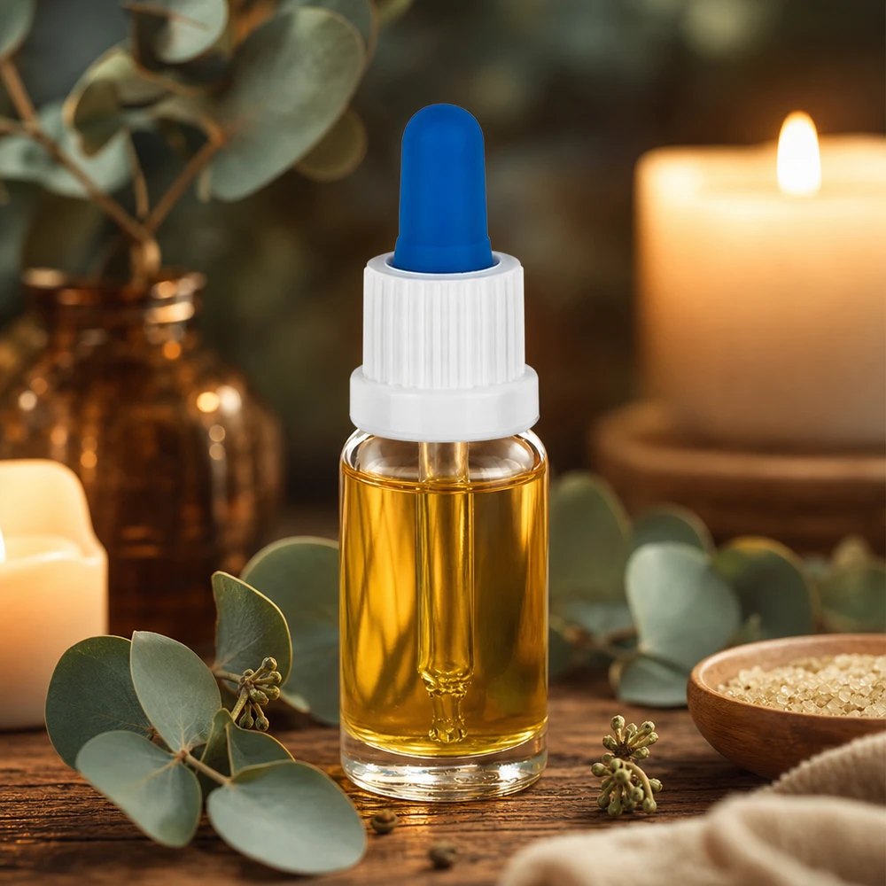 En liten pipettflaska på 10 ml med guldfärgad olja, vit kork och en blå gummikula på ett träbord