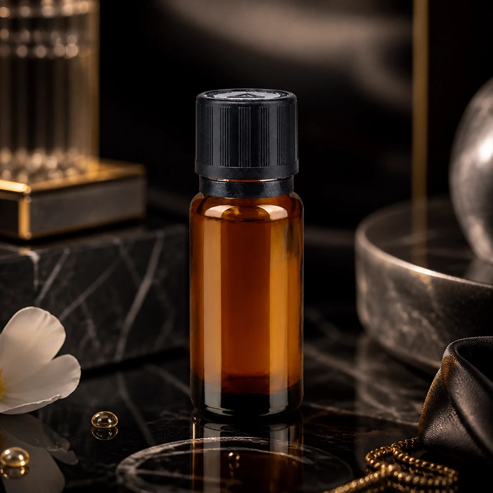 Elegant 10 ml droppflaska i brunt glas med svart originalförslutning på svart marmor