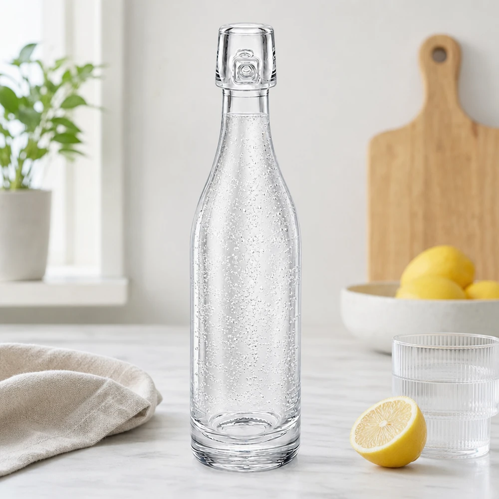 50ml glasflaska utan svängbar topp UNiTWIST 50 ml glasflaska UNiTWIST fylld med kolsyrat vatten i modernt kök bredvid citroner och glas vit bänkskiva