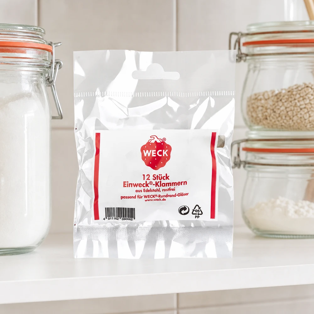 Original WECK-klämmor (förpackning(ar) med 12) WECK klämmer fast produktförpackningar i kök mellan förvaringsburkar med spannmålsmjöl på vit bänkskiva köksmiljö