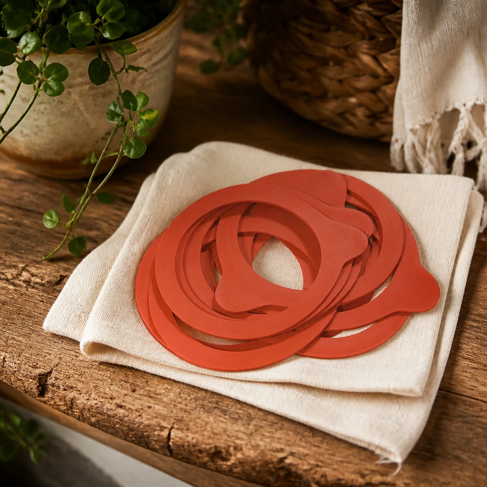 Konserveringsringar RR60 naturgummi orange på linneduk rustikt träbord med växt naturlig köksatmosfär