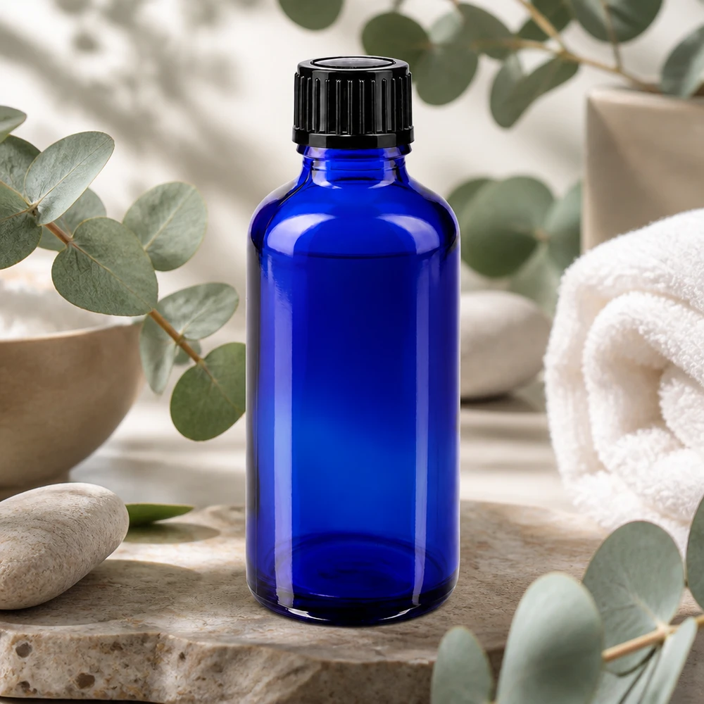 Apoteksflaska blå 50ml skruvkork svart standard Blå 50 ml apoteksflaska i glas med svart skruvlock på natursten med eukalyptus