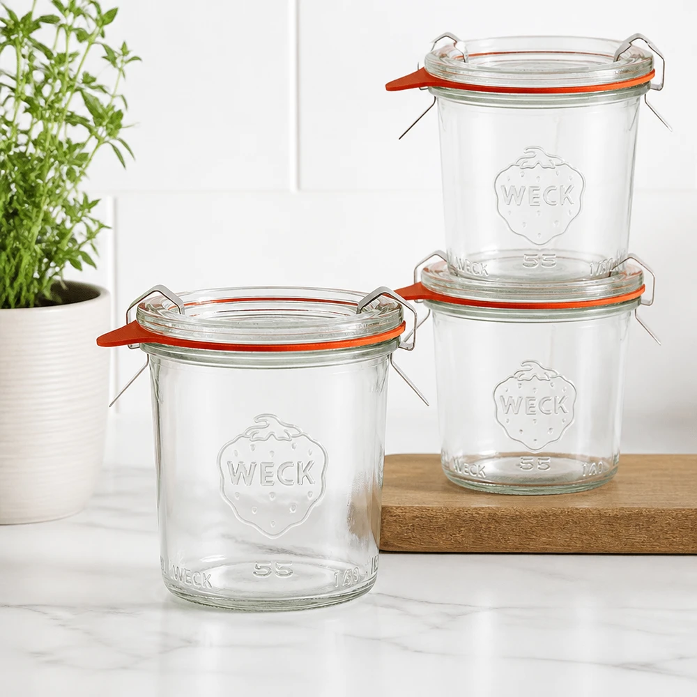 140ml Krossade glasögon komplett WECK RR60 Tre WECK 140ml RR60 tumblers staplade på en träskiva i ett modernt kök med en grön växt i bakgrunden